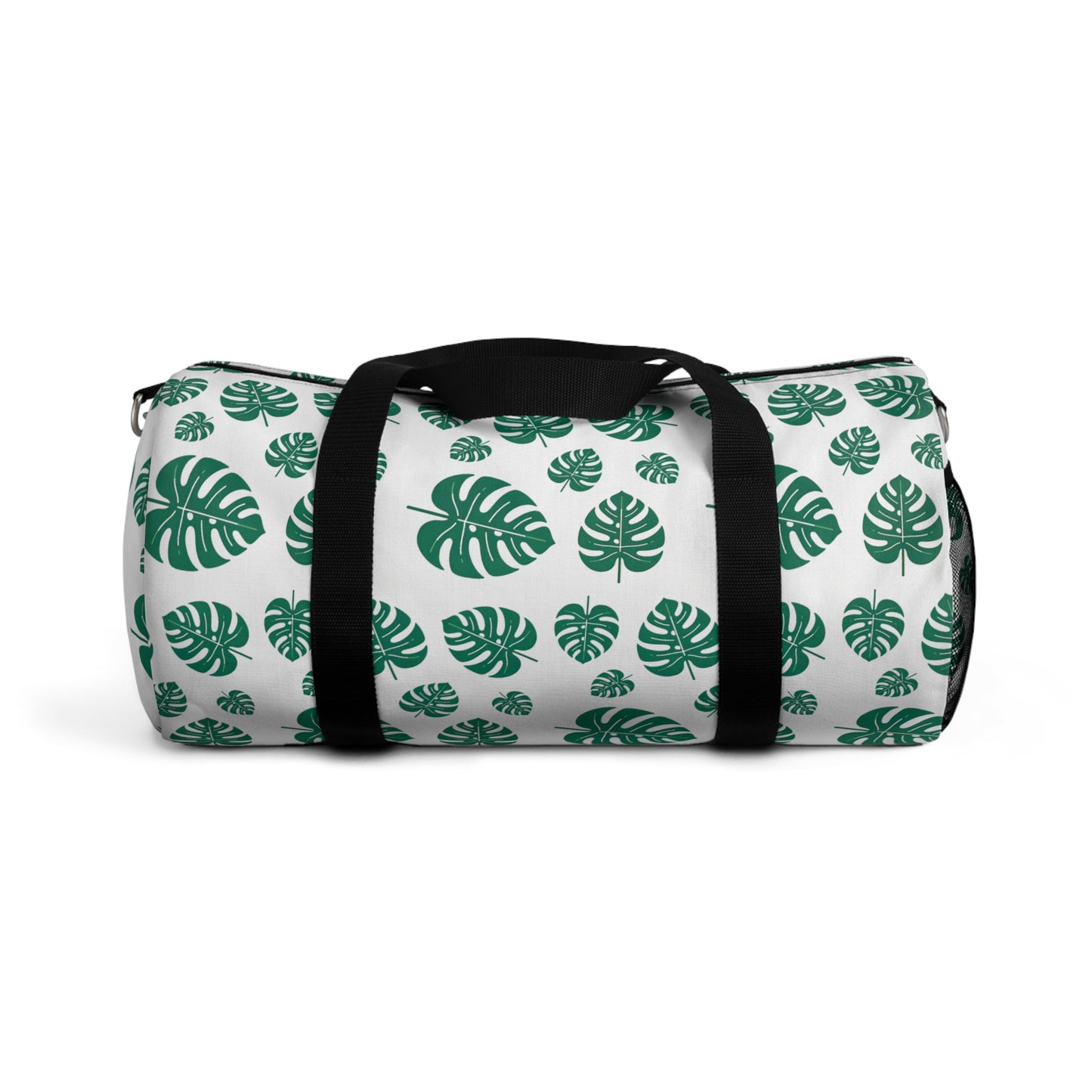 The image shows a cylindrical duffel bag patterned with green tropical leaves and equipped with a black shoulder strap