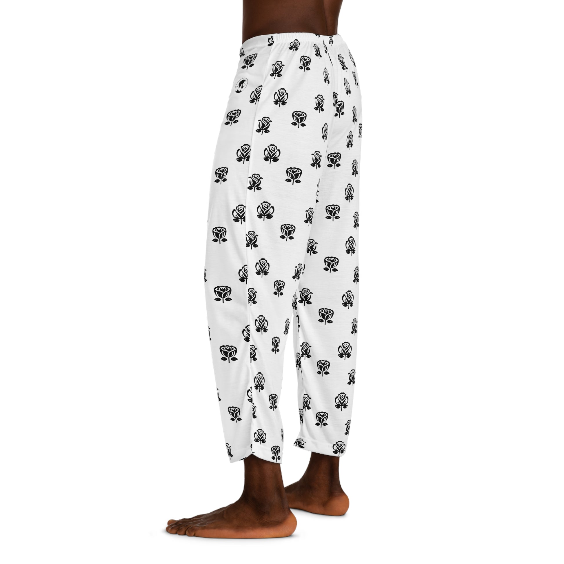 Casual white pajama bottoms decorated with an all-over black rose print, and a contrasting black drawstring at the waist