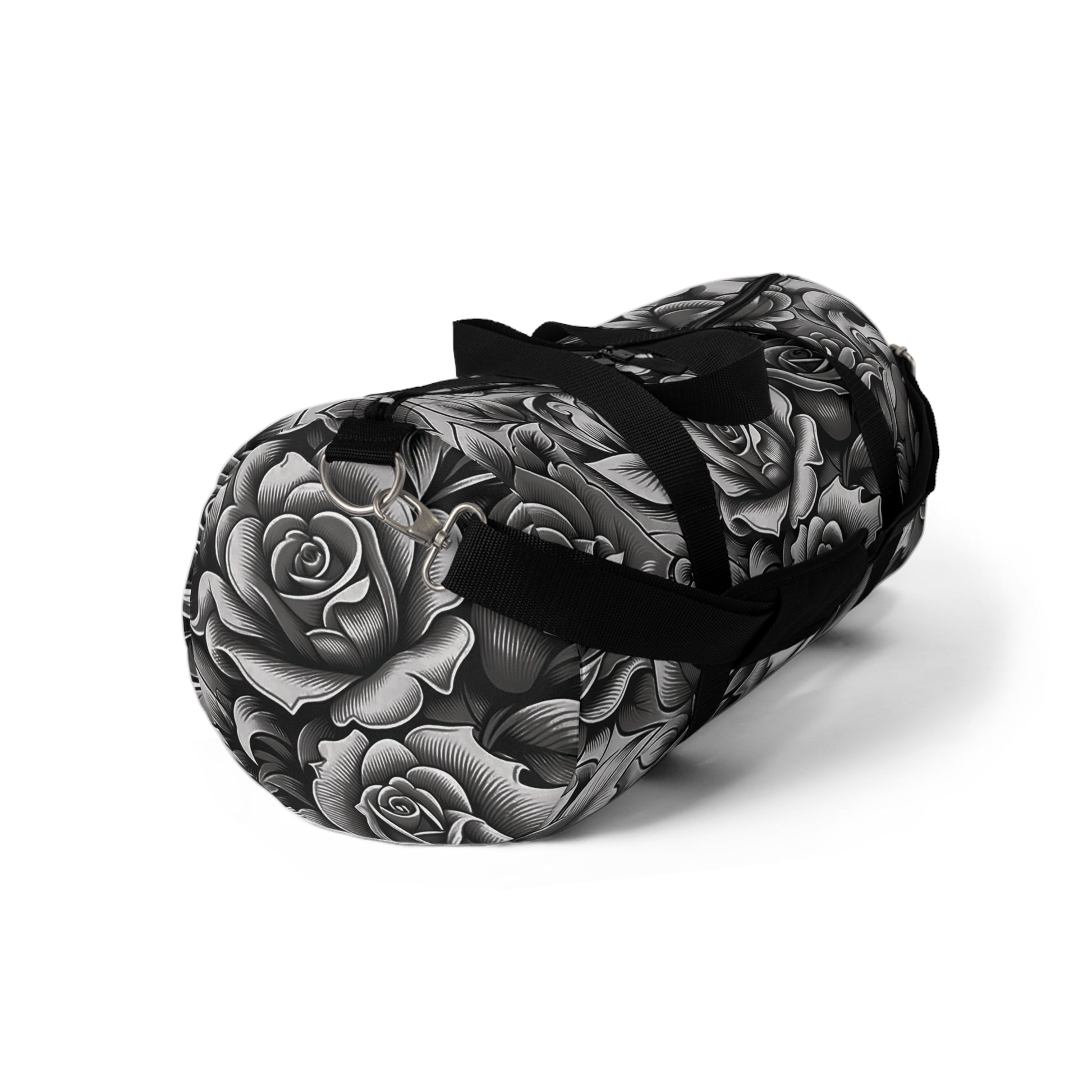 A duffel bag with a monochromatic rose pattern and a black strap.