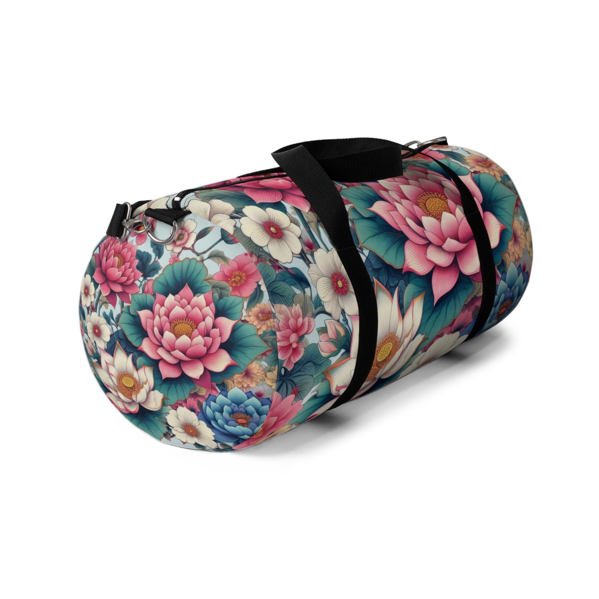 A duffel bag with a vibrant floral pattern featuring large blooms in shades of pink, blue, and white, with green foliage, all set against a dark background. The bag has a black adjustable shoulder strap and black zippers.